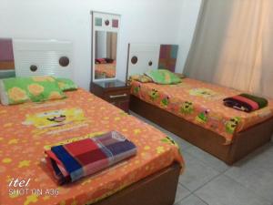 a bedroom with two beds and a mirror at قرية بالميرا السخنه in Ain Sokhna