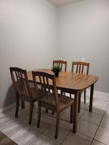 un tavolo in legno con quattro sedie e una pianta sopra di Entire 1-Bedroom Unit in Vibrant 124 Street Arts District a Edmonton