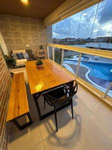 a balcony with a wooden table and a bench at Apartamento em Praia do Francês in Praia do Frances +54 photos