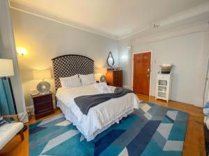 a bedroom with a large bed and a blue rug at Saint Mary10min Walk To Fenwaylongwood Med,mbta in Brookline