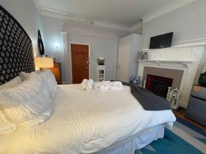 a bedroom with a large white bed with a fireplace at Saint Mary10min Walk To Fenwaylongwood Med,mbta in Brookline
