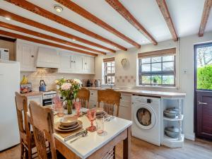 a kitchen with a table with chairs and a washer at The Cottage in Ipswich