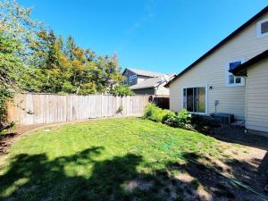 a yard with a fence and a house at The Perfect Getaway (5 mins from Eugene Airport) in Eugene