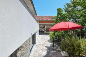 a patio with a red umbrella next to a building at Oscar & Leo Apartments in Zadar