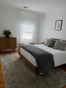 a bedroom with a large bed and a dresser at Parkview Cottage in Henley Beach South