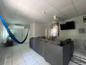 a living room with a couch and a tv at Cuco Beach Paradise Villa in Chirilagua