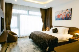 ein Hotelzimmer mit einem Bett und einem Fenster in der Unterkunft Lộc Nguyên Hotel Dalat in Xuan An
