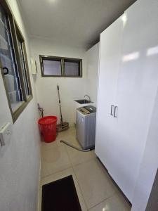 a kitchen with a washer and dryer in a room at FIJI HOME Apartment Hotel in Suva