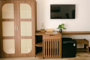 Zimmer mit einem Schreibtisch und einer Holztür in der Unterkunft Lộc Nguyên Hotel Dalat in Xuan An