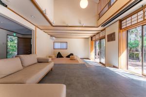 a living room with a couch and windows at プライベートリゾート犬の日 in Hakone