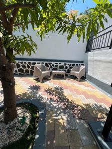a patio with two benches and a tree at Cuco Beach Paradise Villa in Chirilagua
