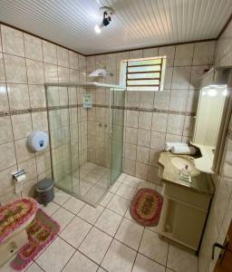 a bathroom with a shower and a sink at Quarto casa Guaporé in Guaporé