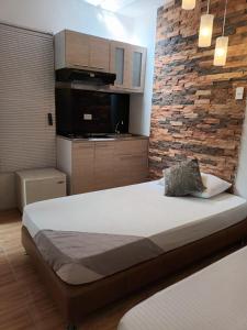 a bedroom with a large bed and a brick wall at Hotel Coffee Real Pereira in Pereira