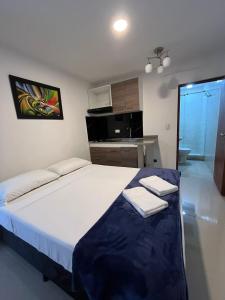 a bedroom with a large bed with two towels on it at Hotel Coffee Real Pereira in Pereira