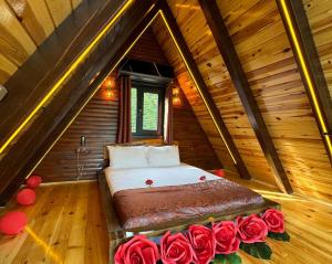 a bedroom with a bed with roses in a attic at RizeHayatburdabungalov in Ardeşen