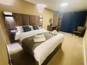 a bedroom with a large bed with towels on it at Hylands Hotel in Coventry
