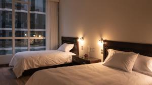 um quarto de hotel com duas camas e uma janela em LIMA HOST em Lima