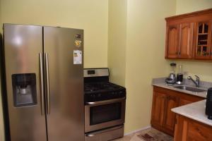 a kitchen with a stainless steel refrigerator and a stove at LW Guesthouse in Montego Bay