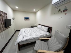 a bedroom with a bed and a couch and a tv at 緯の厝民宿 in Erlin