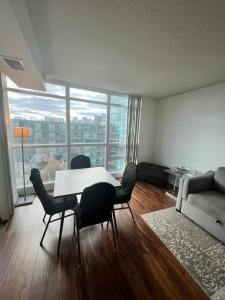 a living room with a table and chairs and a couch at Downtown Toronto Suite By The Lake in Toronto