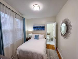a small bedroom with a bed and a mirror at Longwood Medical Condominium in Brookline