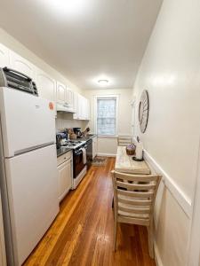 a kitchen with a white refrigerator and a table at Longwood Medical Condominium in Brookline