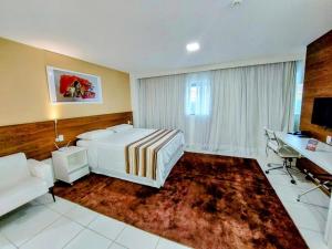 a bedroom with a bed and a desk and a couch at Vision Hotel em Brasília 08101 in Brasilia