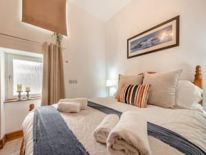 a bedroom with a bed with white sheets and pillows at Gwynfor in New Quay