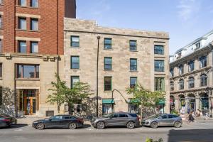 a group of cars parked in front of a building at Le Nomade MTL in Montréal