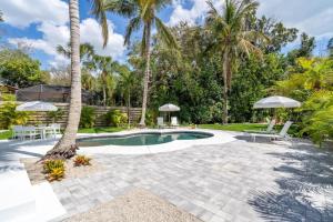 a swimming pool with a patio and palm trees at Luxury getaway steps from beach sleeps 10 in Siesta Key