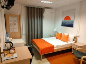 a bedroom with a bed with an orange blanket at Birlik in Tengiz