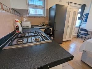 a kitchen with a stove and a refrigerator at Stepney Green Self Contained Studio in London