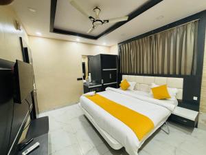 een slaapkamer met een groot bed met gele kussens bij Kings Inn Hotel in Rānchī