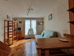 ein Wohnzimmer mit einem blauen Sofa und einem Tisch in der Unterkunft Maison La Faute-sur-Mer, 2 pièces, 4 personnes - FR-1-476-21 in La Faute-sur-Mer