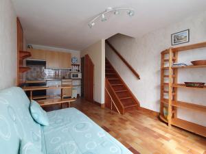 ein Wohnzimmer mit einer Treppe und eine Küche in der Unterkunft Maison La Faute-sur-Mer, 2 pièces, 4 personnes - FR-1-476-21 in La Faute-sur-Mer