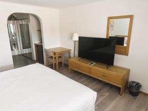 Hotel 191 - Moab في موآب: غرفة نوم بسرير وتلفزيون بشاشة مسطحة