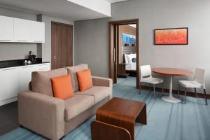 a living room with a couch and a table at Aloft Riyadh Hotel in Riyadh