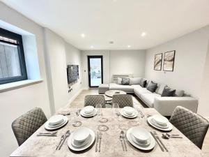 a dining room and living room with a table and chairs at Holocene Luxury Apartments London in The Hyde