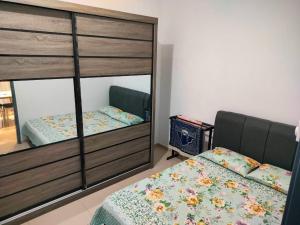 a bedroom with a bunk bed and a mirror at Aiman's Rose HomeStay in Teluk Panglima Garang
