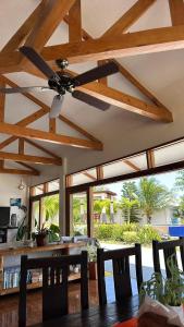 a ceiling fan in a living room with a table and chairs at Villa MountainView Guesthouse in Dimiao