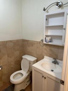 y baño con aseo y lavamanos. en Executive Room E with Private Bathroom Divine Villa and Resorts 5mins to EWR Airport and 4mins to Penn Station Newark, New York, en Newark