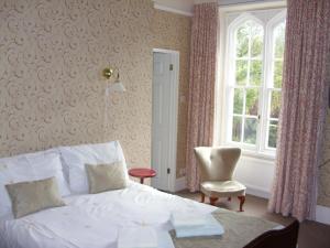 a bedroom with a bed and a chair and a window at Meadowbank in Ambleside