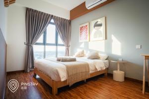 a bedroom with a bed with a large window at K Avenue by Pinstay in Donggongon