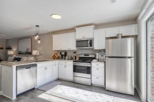 a kitchen with white cabinets and stainless steel appliances at 1408 Perrin Dr, Unit B - Ocean Walk Sleeps 8 in Myrtle Beach