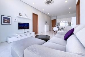 أجنحة سوهو كيه إل سي سي باي ليلا في كوالالمبور: غرفة معيشة بيضاء مع أريكة وتلفزيون