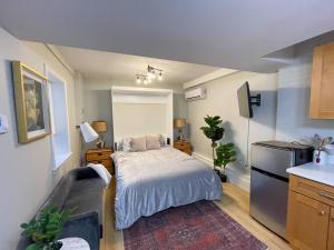 a small bedroom with a bed and a kitchen at Renovated Studio, Near Hospitals, Mbta in Boston