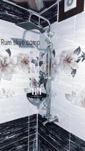 a shower in a bathroom with flowers on the wall at Rum Skye camp in Wadi Rum