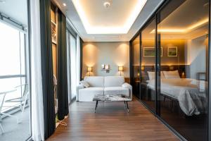 un soggiorno con letto e divano bianco di Bona Haeundae fantastic ocean view #Sea and Haeundae Gunam-ro# a Busan