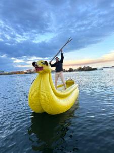 a man is in a banana boat in the water at Uros Walysuma Titicaca Lodge in Puno