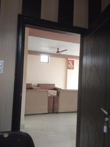 eine Tür, die in ein Zimmer mit einem Sofa führt in der Unterkunft Haridwar and kedarnath dharmshala in Haridwar